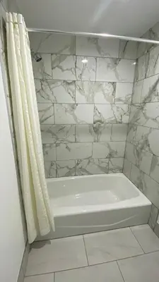 a white bath tub with a shower curtain in a bathroom at Plaza Inn Motel - Los Angeles area in Rosemead