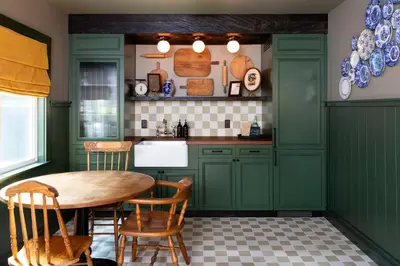 a kitchen with green cabinets and a table and chairs at NP Boutique Lodge in Big Bear Lake