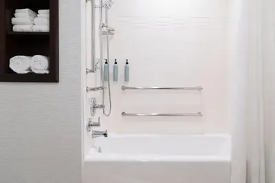 a bathroom with a tub and a shower with towels at Residence Inn by Marriott Anaheim Brea in Brea
