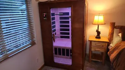 a bedroom with a window and a lamp next to a bed at A Snowmass Haven - EV, Sauna, Hot Tub - Walk to Slopes/lake in Big Bear Lake