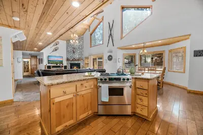 a kitchen with wooden cabinets and a stove at A Snowmass Haven - EV, Sauna, Hot Tub - Walk to Slopes/lake in Big Bear Lake