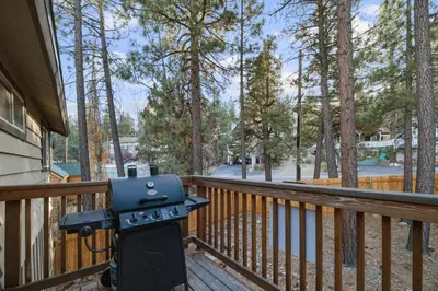 a grill sitting on a wooden deck with trees at Lakeview Trout N About - Walk to Lake, Close to Village & Slopes in Big Bear Lake