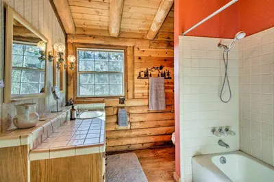 a bathroom with a sink and a bath tub at Pine Mountain Club Log Home with Deck and Grill! in Pine Mountain Club