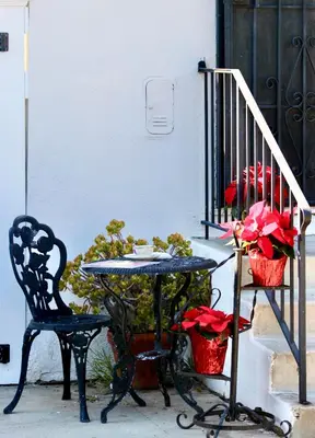 a table and a chair and a table with red flowers at The Hi Point Estate in Los Angeles