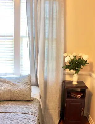 a bedroom with a bed and a vase of flowers on a table at The Hi Point Estate in Los Angeles
