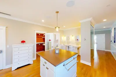 a kitchen with white cabinets and a wooden counter top at Gull Cottage in Seal Beach
