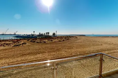 a sandy beach with the sun shining on it at Gull Cottage in Seal Beach