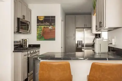 a kitchen with a counter with two chairs in it at Coziest 1BD Bungalow 8min from airport, 4 min SoFi in Los Angeles