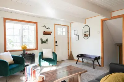a living room with green chairs and a table at Aery Pines in Wrightwood