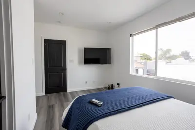 a bedroom with a bed and a tv on the wall at Bungalow w Free Parking 4 min from SoFi, 8min from airport in Los Angeles