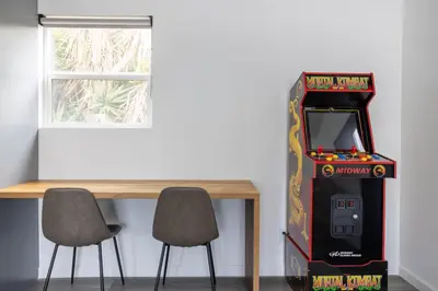 a table with two chairs and a pinball machine at Bungalow w Free Parking 4 min from SoFi, 8min from airport in Los Angeles