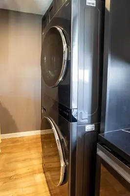 a microwave and a washer and dryer in a kitchen at Newly Renovated Bungalow w Free Parking 4min from SoFi, 8min from Airport in Los Angeles