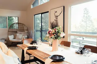 a dining room with a table with flowers on it at Modern Treetop Cabin by Lake Arrowhead Village in Lake Arrowhead