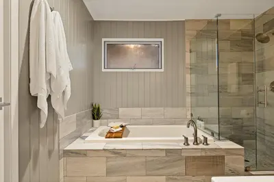a bathroom with a tub and a glass shower at Modern Treetop Cabin by Lake Arrowhead Village in Lake Arrowhead