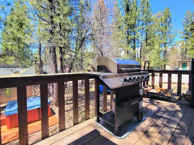 a grill on the deck of a house at Four Seasons Getaway-Private Hot Spa with Pine Tree Views-Walk to Village and Pineknot Trailhead-Plus King Bed! in Big Bear Lake