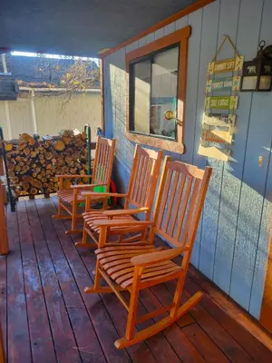 three wooden rocking chairs sitting on a porch at Four Seasons Getaway-Private Hot Spa with Pine Tree Views-Walk to Village and Pineknot Trailhead-Plus King Bed! in Big Bear Lake