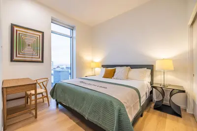 a bedroom with a bed and a desk and a window at @ Marbella Lane - Aesthetic 2BR w/Ocean views in Long Beach