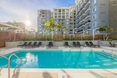 a swimming pool with chairs and buildings in the background at @ Marbella Lane - Aesthetic 2BR w/Ocean views in Long Beach