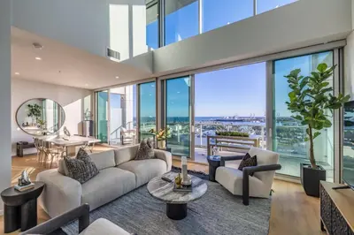 a living room with a couch and tables and glass windows at @ Marbella Lane - Luxurious 3BR Penthouse in Long Beach