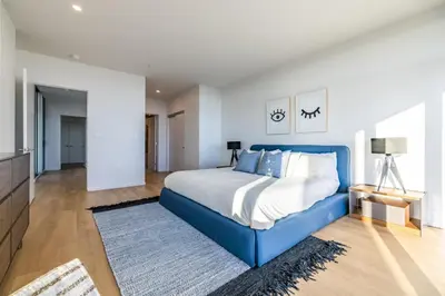 a bedroom with a blue bed and a television at @ Marbella Lane - Luxurious 3BR Penthouse in Long Beach