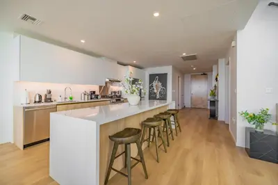 a kitchen with a white counter and bar stools at @ Marbella Lane - Penthouse w/ City & Ocean Views in Long Beach