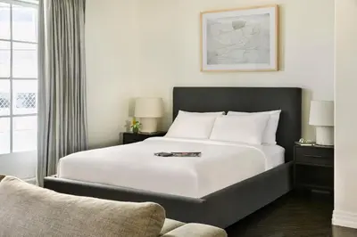 a bedroom with a large white bed and a chair at The Eden in Los Angeles