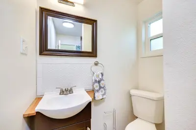 a bathroom with a sink and a toilet and a mirror at Quiet Carpinteria Cottage By Town and Beaches in Carpinteria