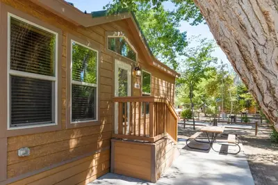 a wooden house with a porch and a picnic table at Adorable little cabin #28 in Kernville