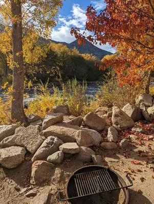 a grill in a pile of rocks next to a river at Deluxe little cabin 2 min stroll to Kern River in Kernville
