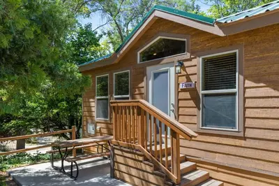 a wooden cabin with a porch and a door at Deluxe little cabin 2 min stroll to Kern River in Kernville