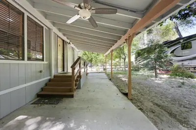 a porch with a ceiling fan and stairs on a house at The Sequoia House in Kernville