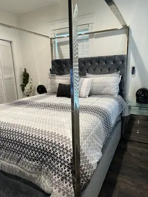 a bedroom with a bed with a black and white comforter at Gorgeous DTLA w/ View + Hot Tub! in Los Angeles