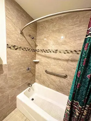 a bathroom with a white tub and a shower at Tropic West Motel in Bell