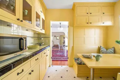 a kitchen with yellow cabinets and a table in it at The Spanish Hideaway in Los Angeles