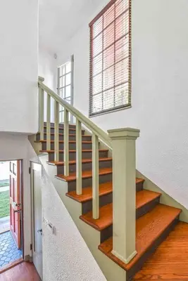 a staircase in a white house with a window at The Spanish Hideaway in Los Angeles