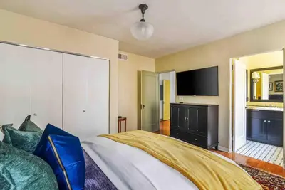 a bedroom with a large bed and a flat screen tv at The Spanish Hideaway in Los Angeles