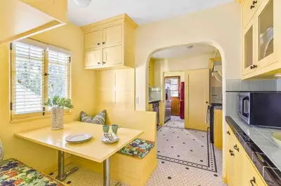 a kitchen with yellow walls and a table in a room at The Spanish Hideaway in Los Angeles