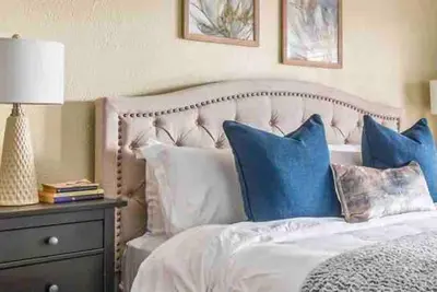 a bedroom with a white bed with blue pillows at The Spanish Hideaway in Los Angeles
