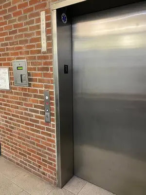 a metal door on a brick wall with a sign at Glendale Americana 2 Bedroom 2 Bathroom Condo in Glendale