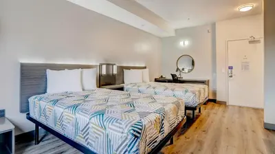 a hotel room with two beds and a mirror at Motel 6 Highland CA San Bernardino East in Highland