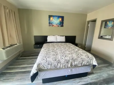 a bedroom with a bed and a painting on the wall at City Center Motel - Oxnard in Oxnard