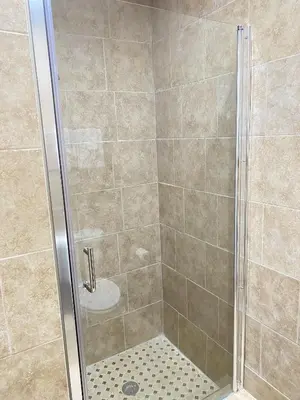 a shower stall with a glass shower door at City Center Motel - Oxnard in Oxnard