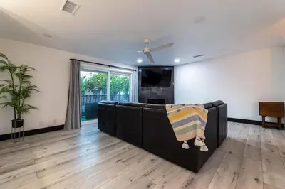 a living room with a couch and a flat screen tv at Modern San Pedro Home, Sleeps 12, Hot Tub, Fire Place, Private Parking in San Pedro