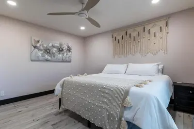 a bedroom with a bed and a painting on the wall at Modern San Pedro Home, Sleeps 12, Hot Tub, Fire Place, Private Parking in San Pedro