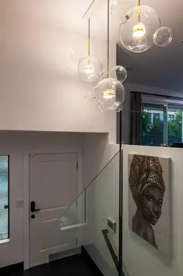a staircase with two lights and a picture of a head at Modern San Pedro Home, Sleeps 12, Hot Tub, Fire Place, Private Parking in San Pedro