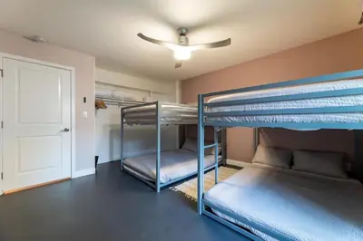 two bunk beds in a room with a ceiling fan at Modern San Pedro Home, Sleeps 12, Hot Tub, Fire Place, Private Parking in San Pedro