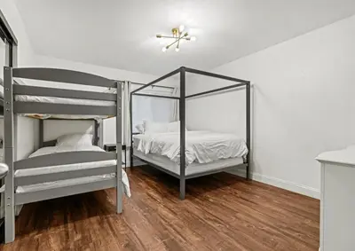 two bunk beds in a room with wood floors at Elegant Hollywood Retreat - Spacious 2BR 2BA Condo with Resort-Style Amenities in Los Angeles
