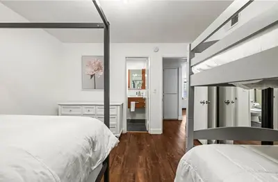 a white bedroom with two beds and a desk at Elegant Hollywood Retreat - Spacious 2BR 2BA Condo with Resort-Style Amenities in Los Angeles