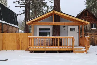 a small cabin with a porch in the snow at The Blue Lake Cabin! 1 min Walk to SnowPlay! in Big Bear City