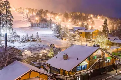 a ski resort with a snow covered slope at night at The Blue Lake Cabin! 1 min Walk to SnowPlay! in Big Bear City